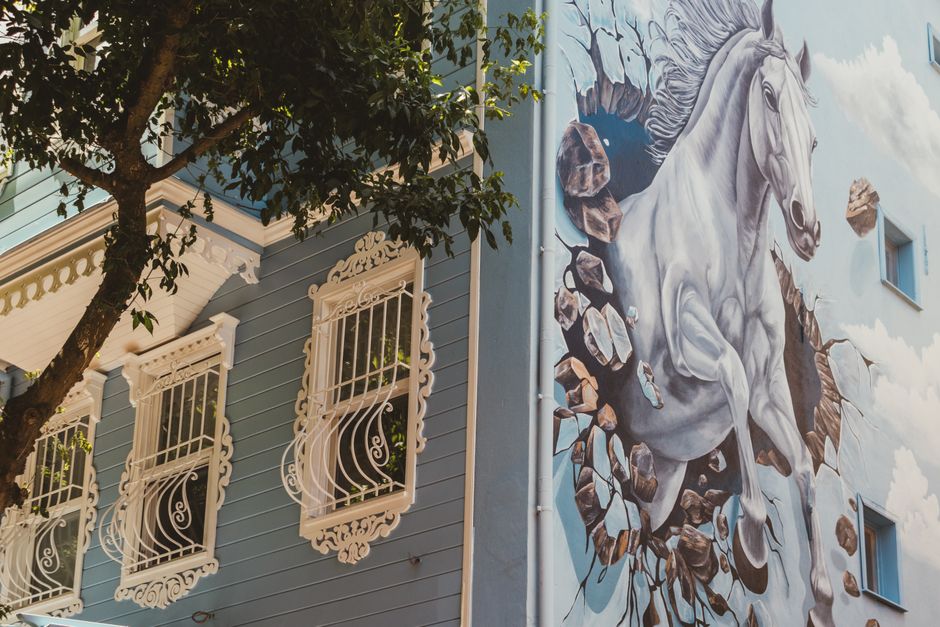 A blue painted wall with ornate window frames